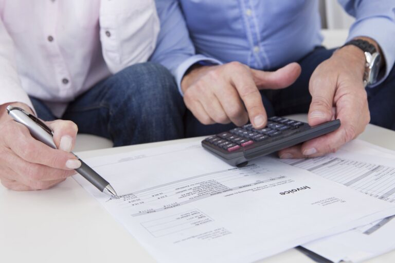 Calculating figures on a calculator over paperwork
